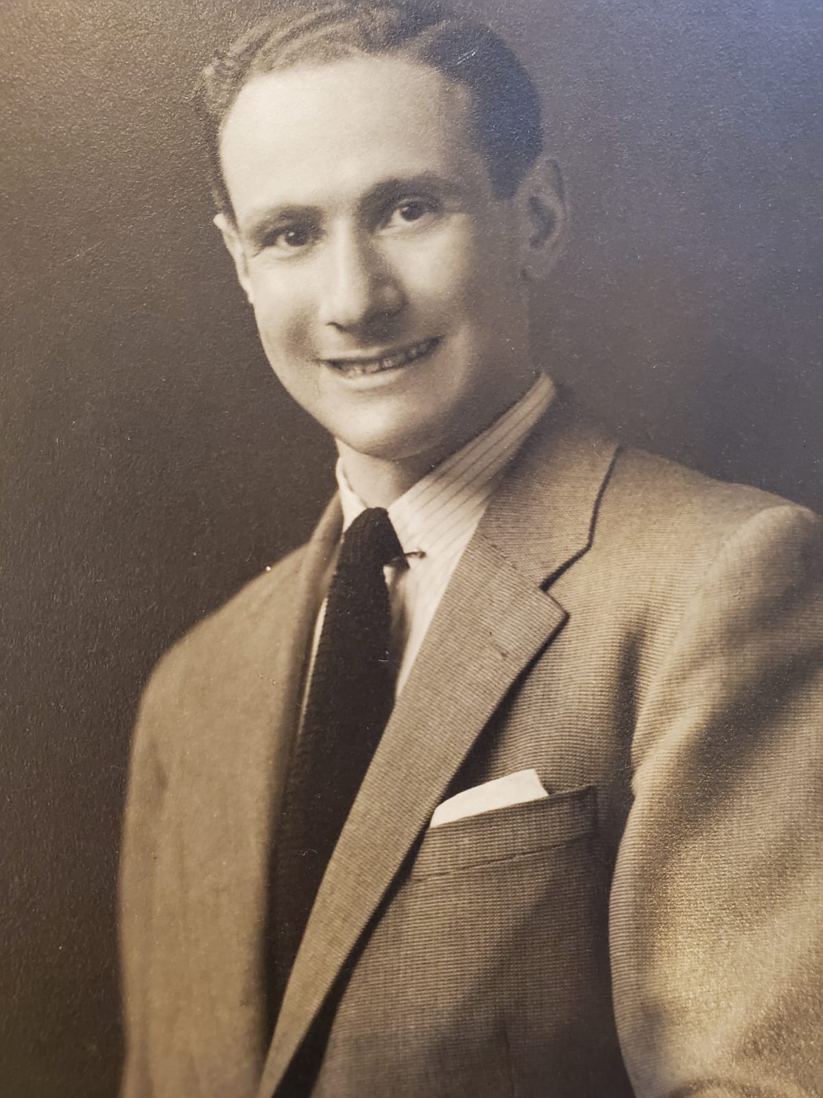 Studio portrait of Adolf Dolf Reichenbach as an adult, smiling in a suit and tie