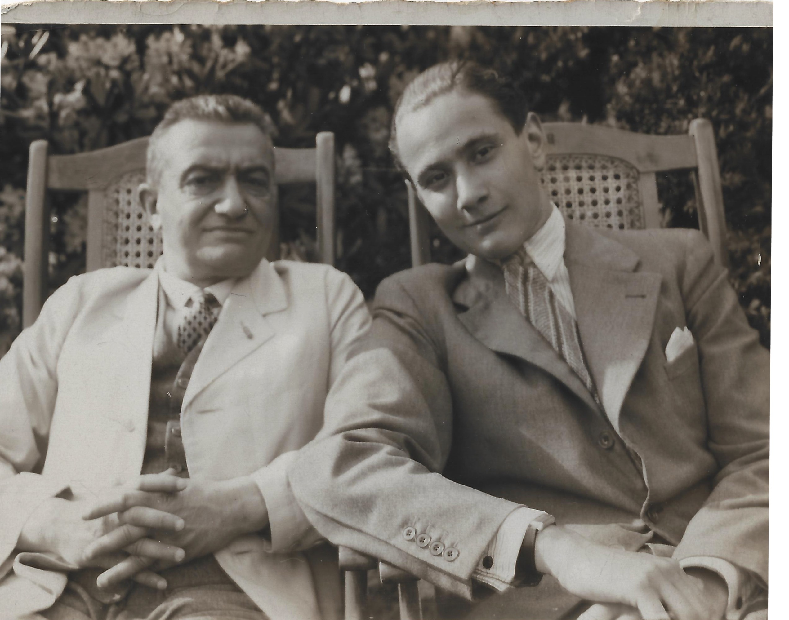 Paul Reichenbach and his adult son Dolf seated together outdoors