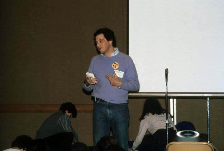A young Paul J. Reichenbach speaking to a seated group during an educational session