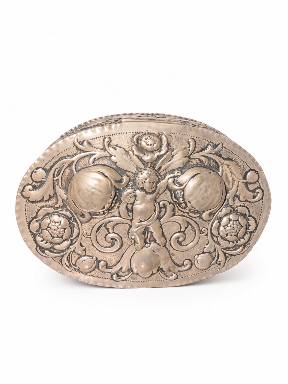Top view of the oval silver-coloured box with a central putto among fruit, flowers and scrolling leaves